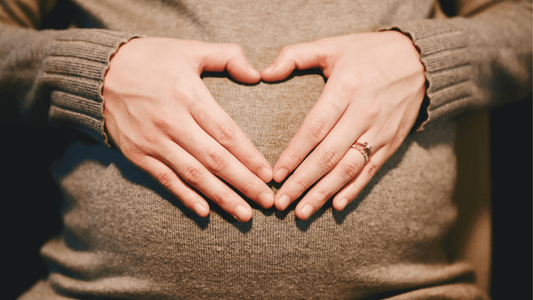 Femme enceinte avec un coeur sur le ventre